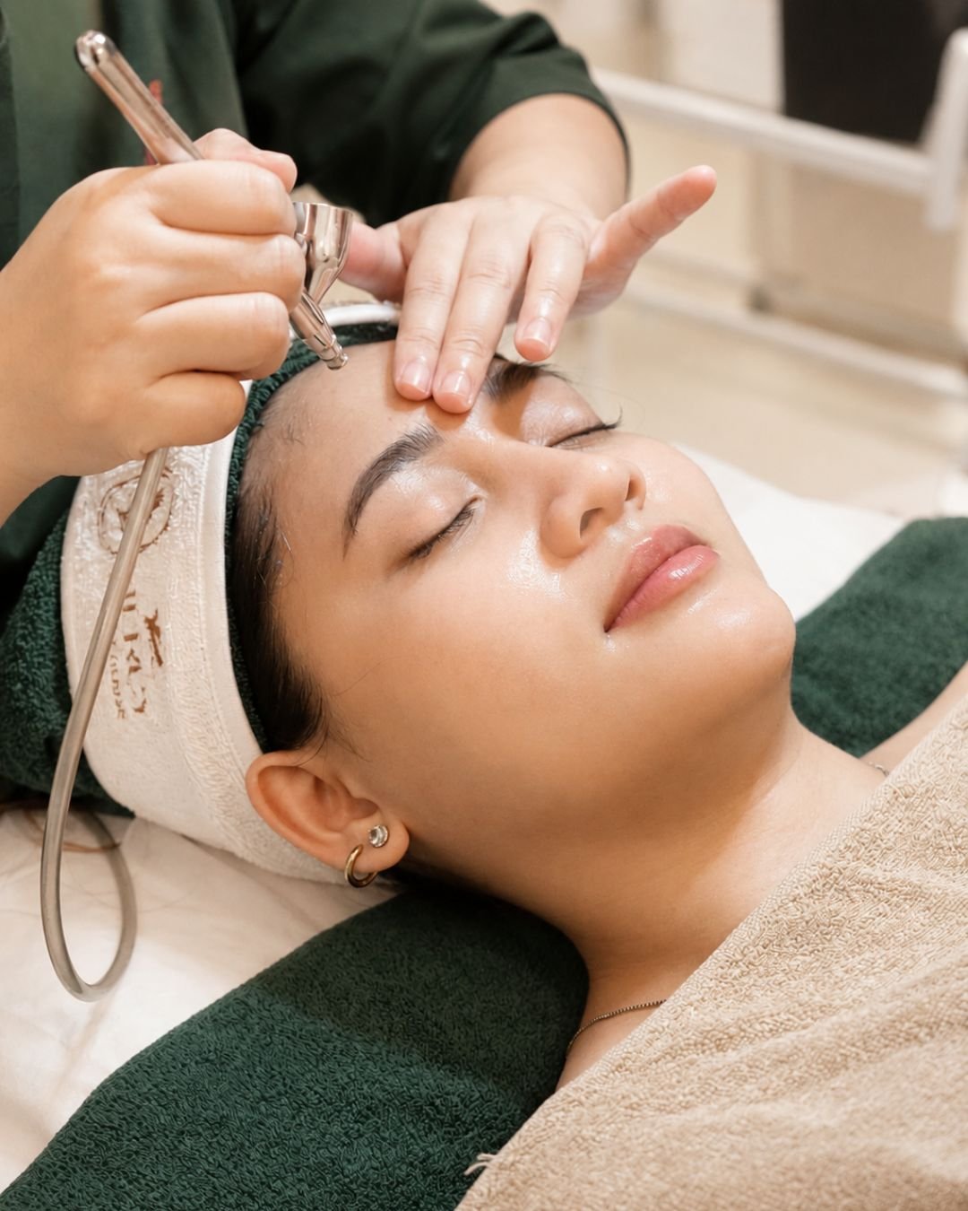 Terapis melakukan Snow White Facial dengan semprotan oksigen pada wajah pasien di The Mercy Clinic